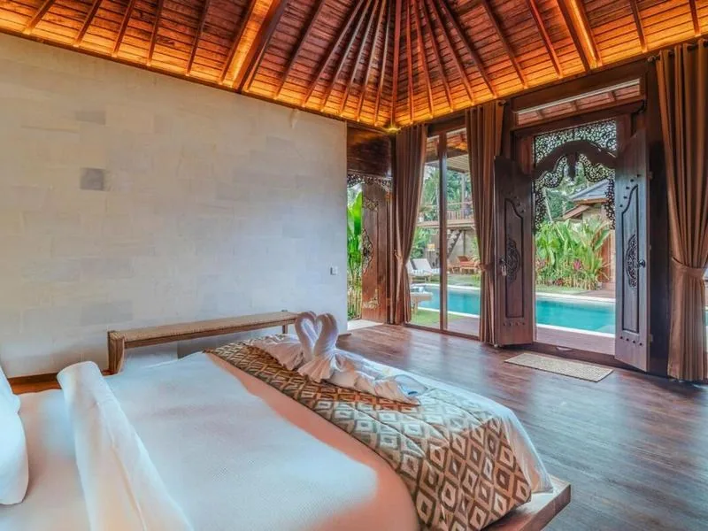 Master bedroom with carved door and pool view