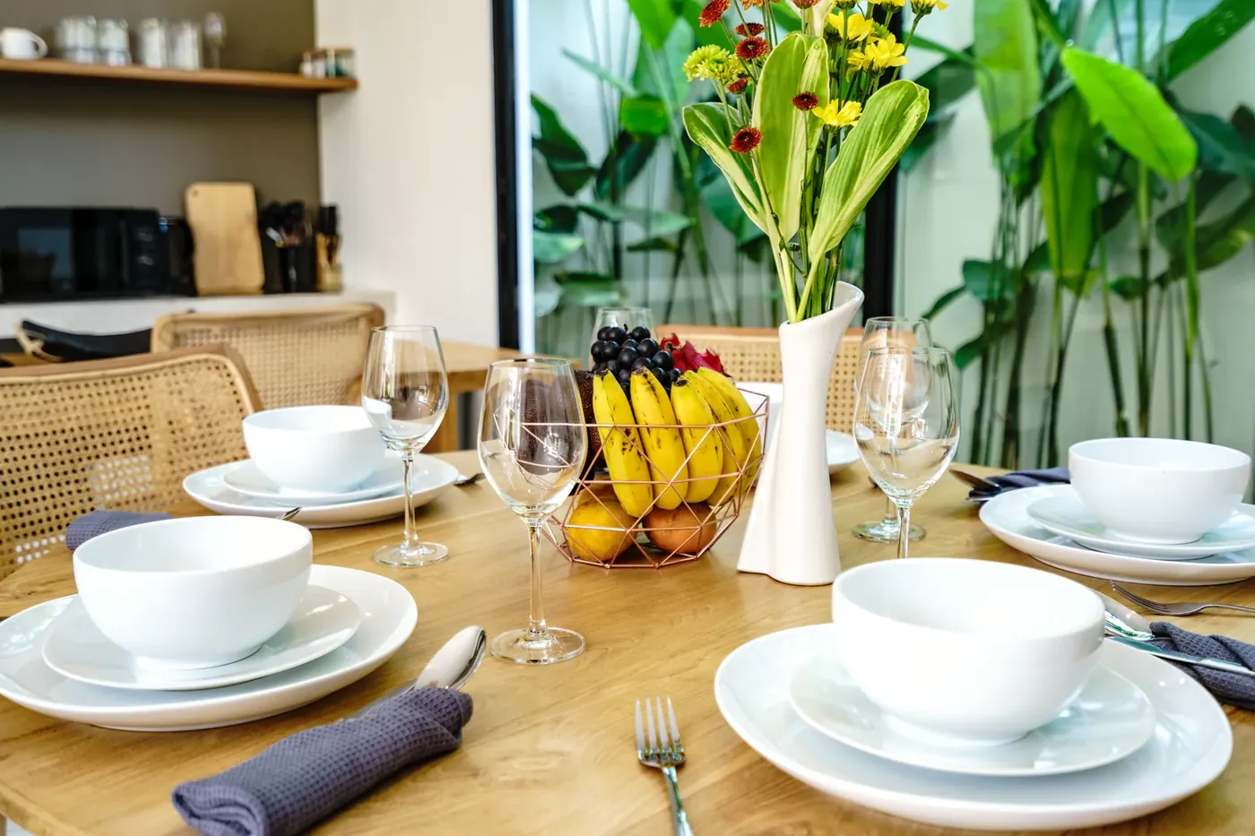Villa Oasis dining table set beside full-height garden glass