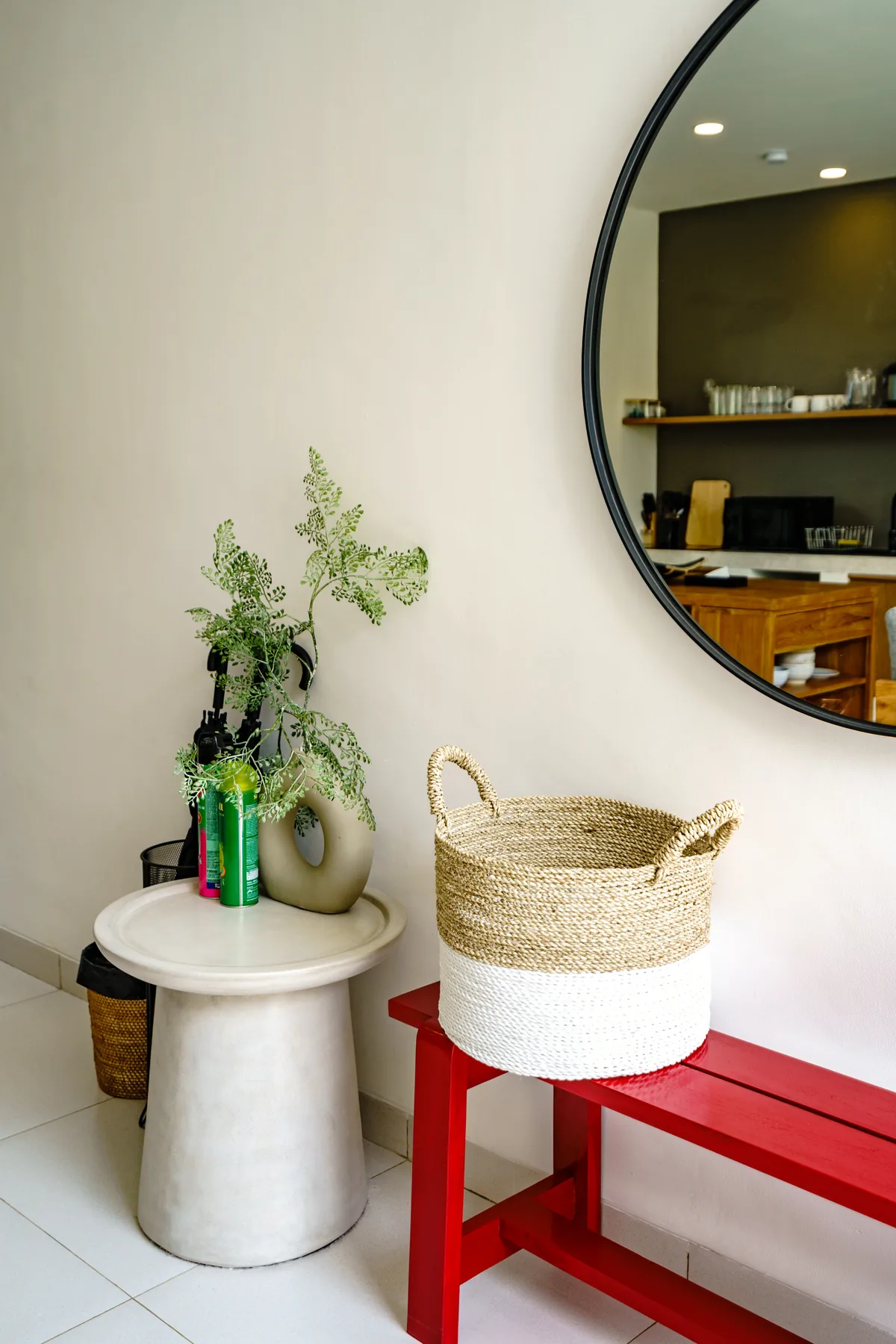Villa Oasis entry vignette with round mirror and red bench